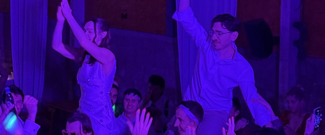 Wedding Dancefloor Shoulder Lift | Mr Beats DJ Wedding guests lifted onto friends' shoulders on a lively dancefloor under purple DJ lighting