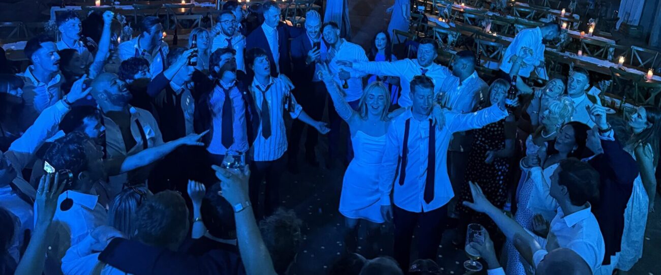Bride & Groom's Final Wedding Song | Mr Beats Bride and groom celebrating their final wedding song with guests on a packed dancefloor under blue DJ lighting